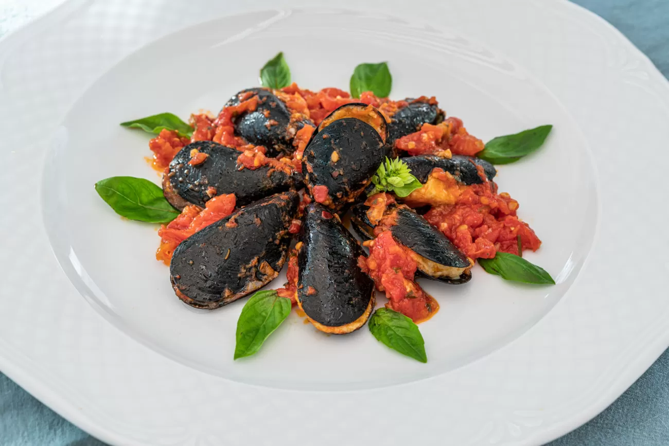 Cozze farcite con mortadella in sugo di pomodoro – food photography per piatti di mare