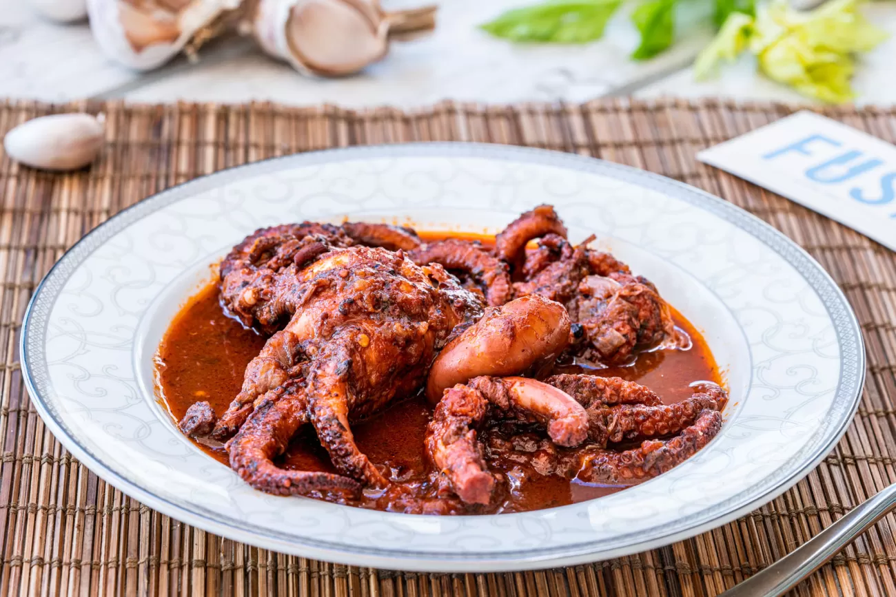 Polpo ubriaco cotto in vino rosso con spezie – fotografia food per cucina tradizionale