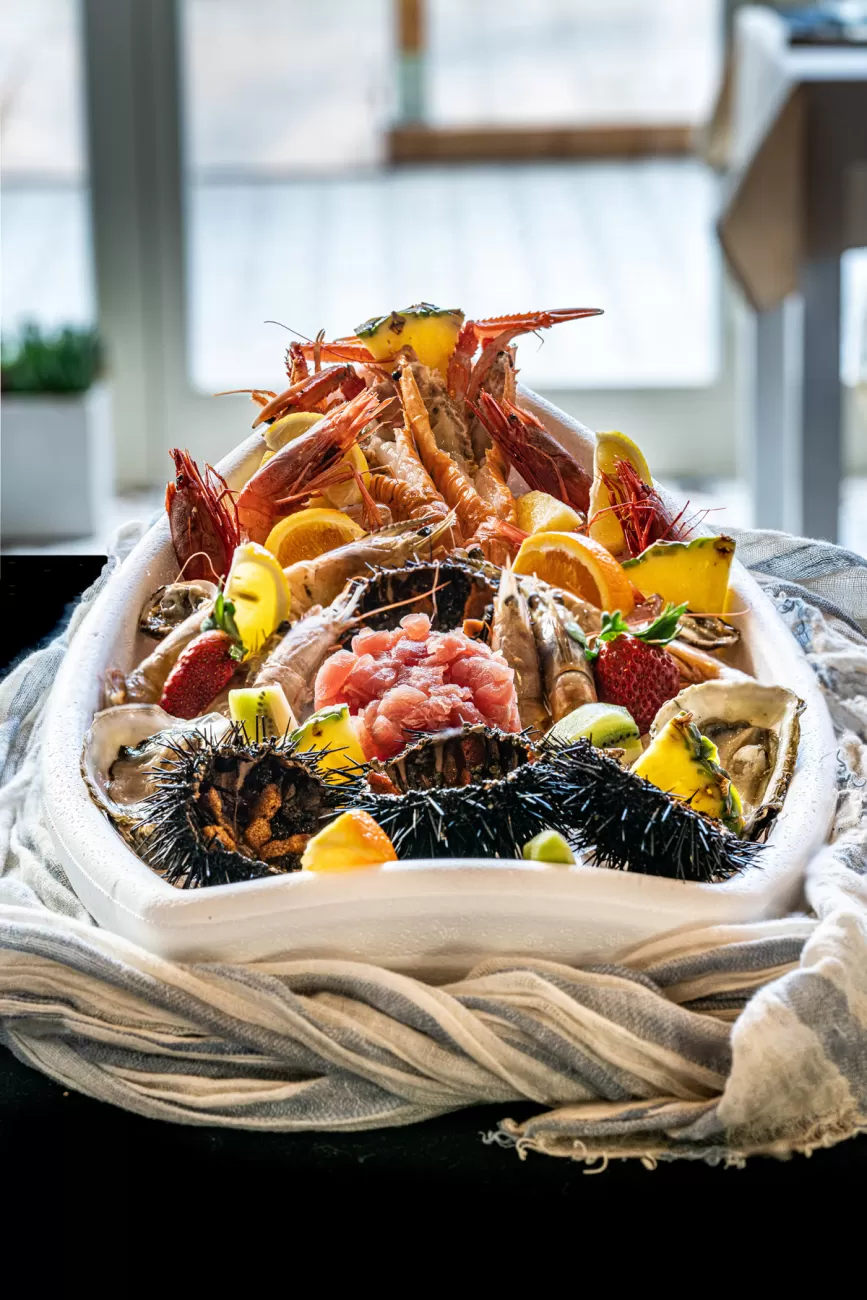 Gran barca di frutti di mare con ricci e frutta esotica – food photography per ristoranti gourmet