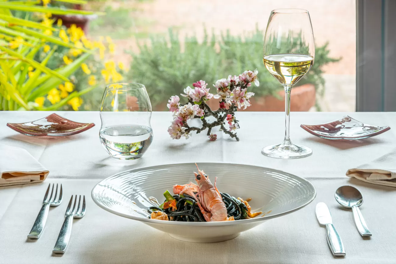 Tagliolini al nero di seppia con scampi e asparagi, piatto simbolo del Ristorante Il Doretto – Cecina, Toscana