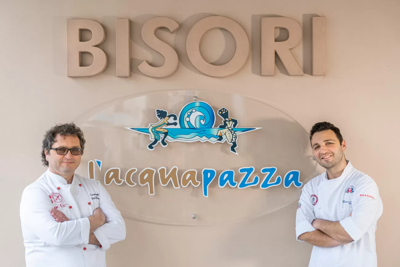 Ritratto degli chef del Ristorante Acquapazza di fronte all’insegna del locale