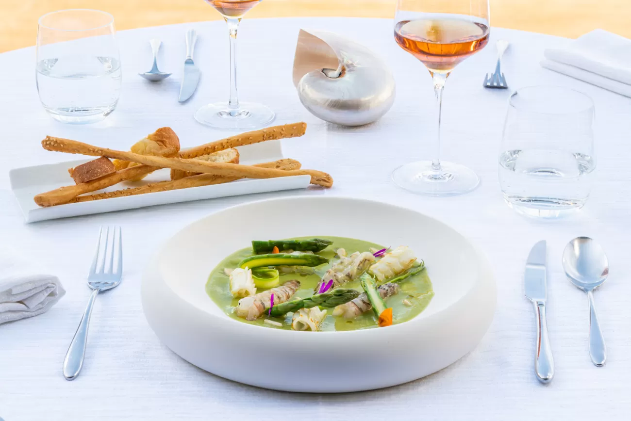 Vellutata di asparagi con mazzancolle crude e calamari al vapore, piatto iconico del Ristorante El Volver