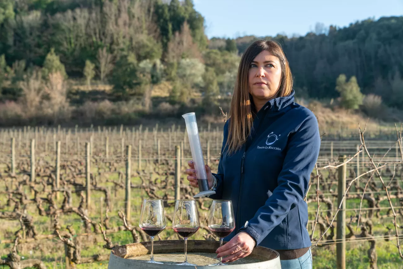 Letizia Martelli mentre serve il vino con il provino – tra i filari della Tenuta La Macchia