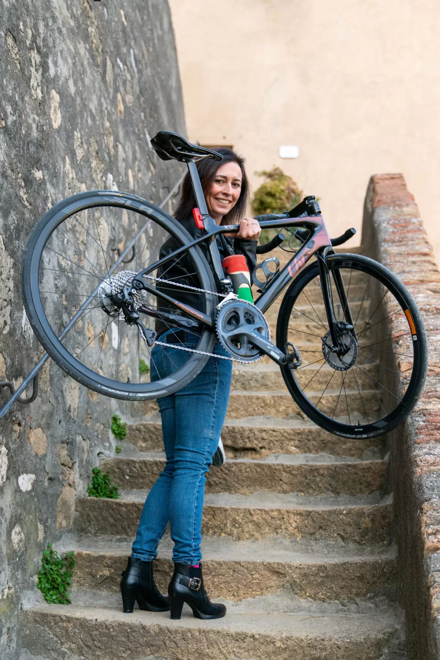 Contrasto tra femminilità e sport – Silvia sale le scale con la bici e i tacchi