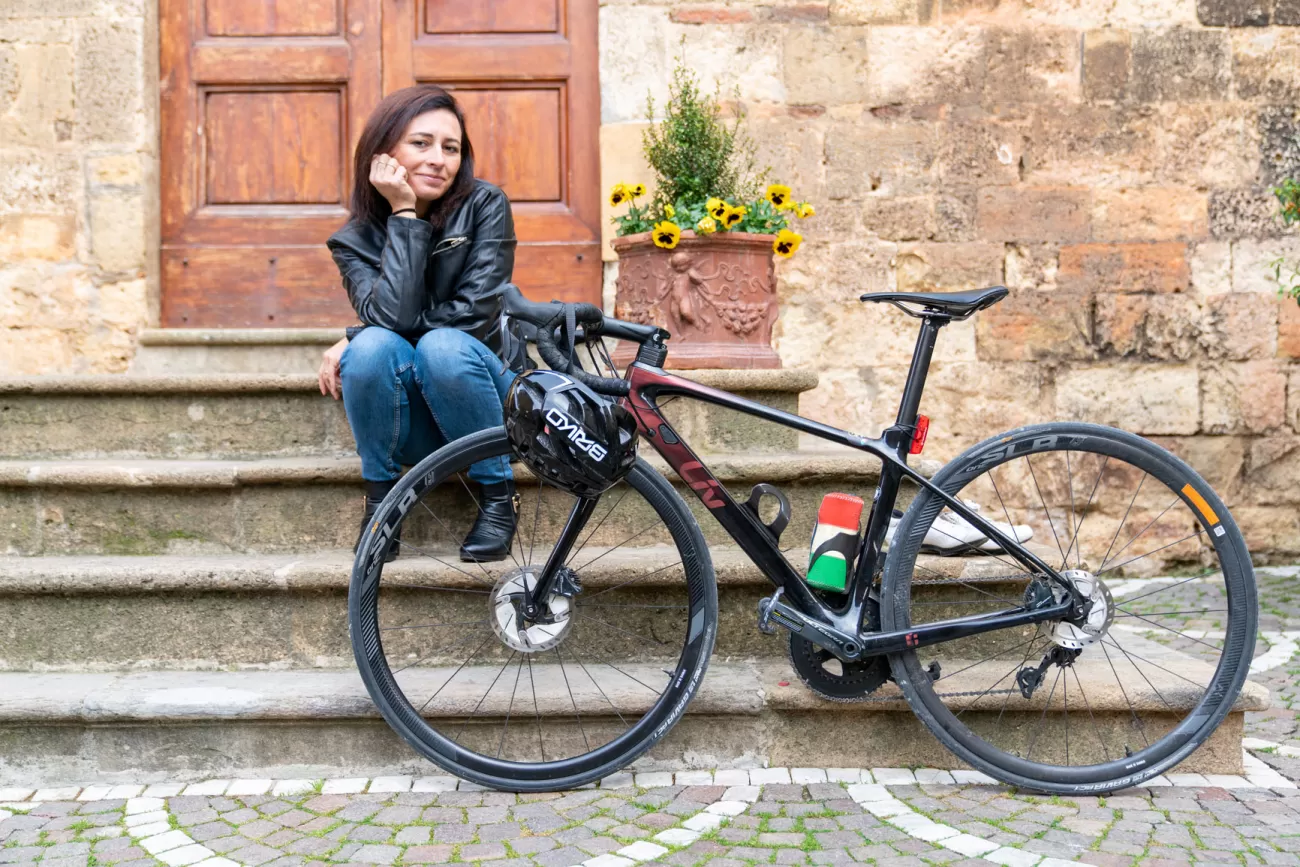Silvia seduta sui gradini con la bici davanti – composizione simbolica