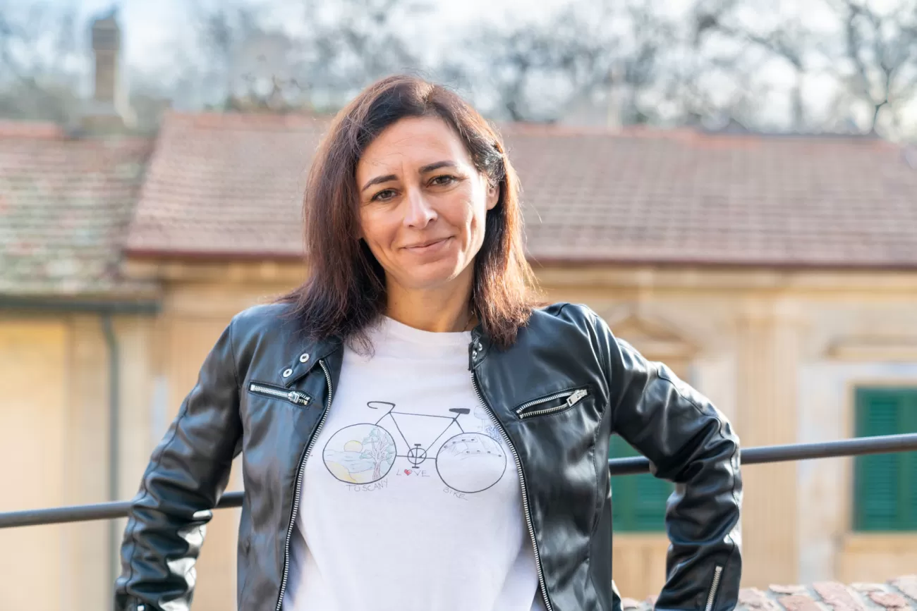 Ritratto a mezzo busto di Silvia Parietti con panorama architettonico di Bibbona sullo sfondo