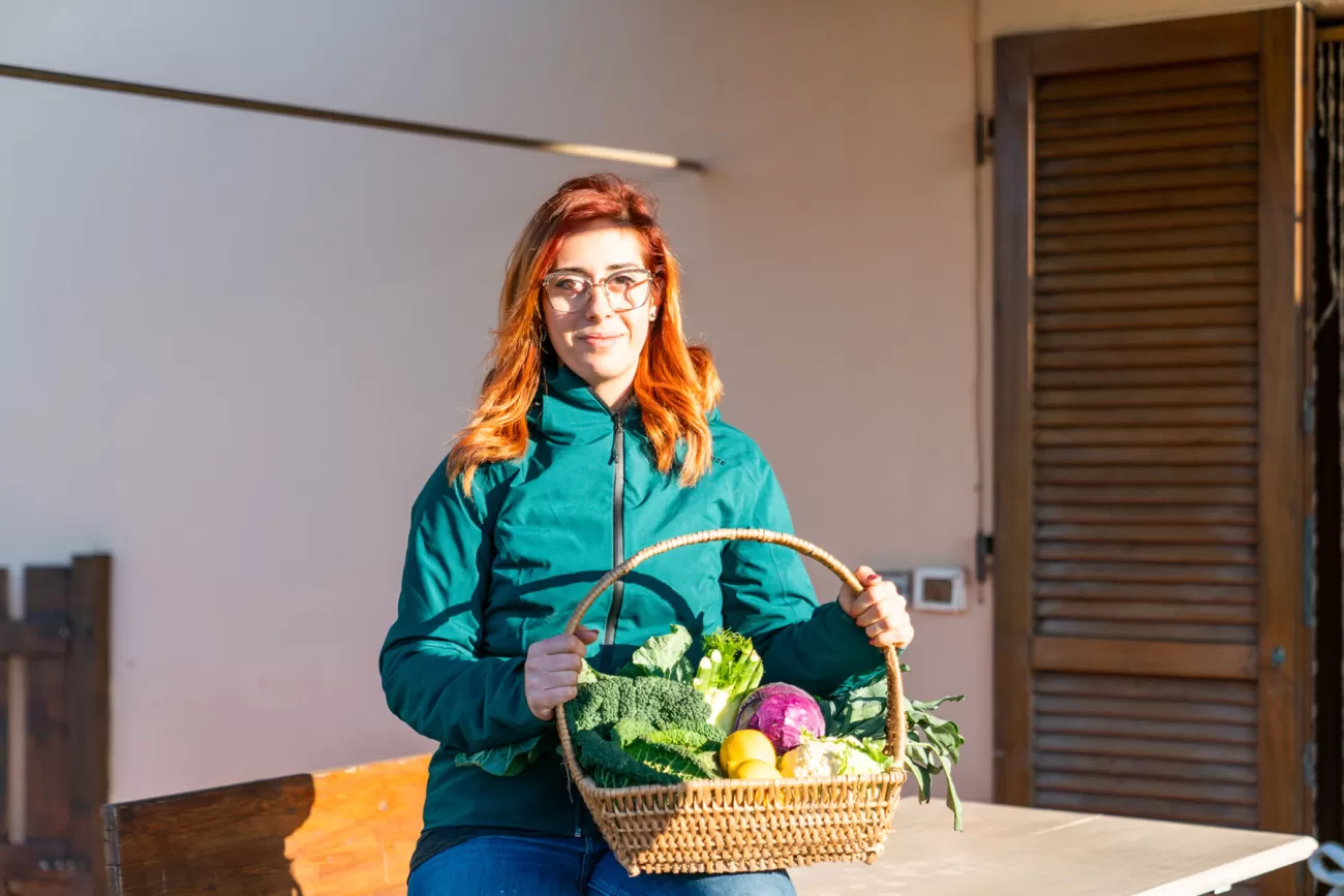 Servizio fotografico ambientato per agriturismo in Toscana – Giulia Filippi con cesto di verdure