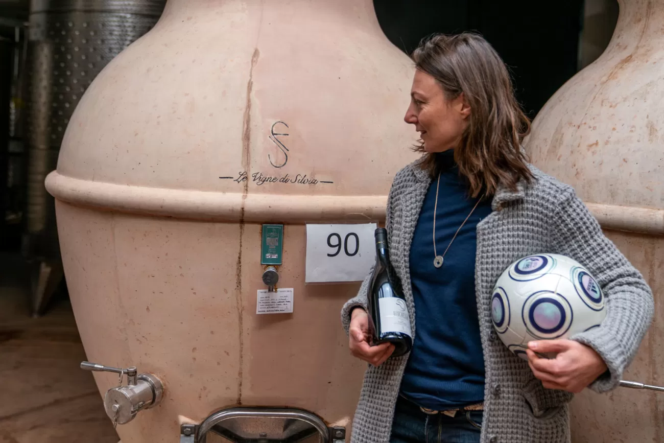 Silvia Fuselli in cantina accanto a un’anfora di terracotta – con vino e pallone
