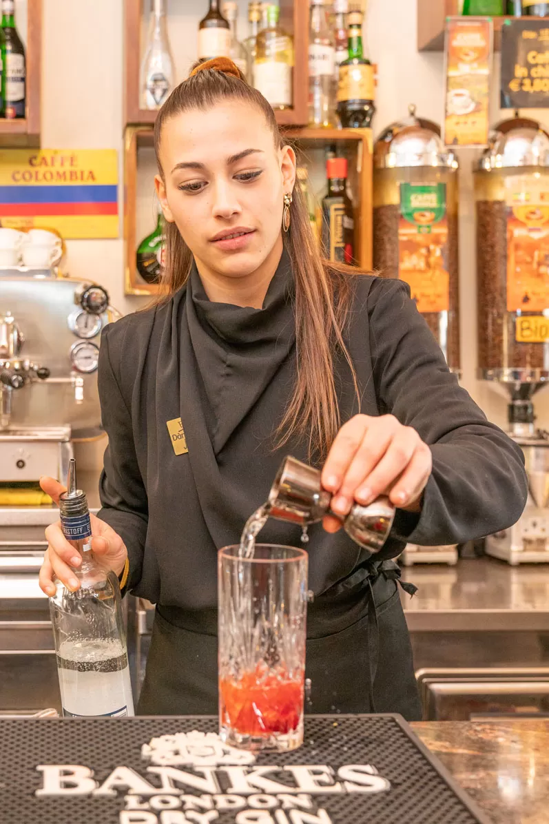 Il liquido viene versato nel bicchiere – cocktail in costruzione