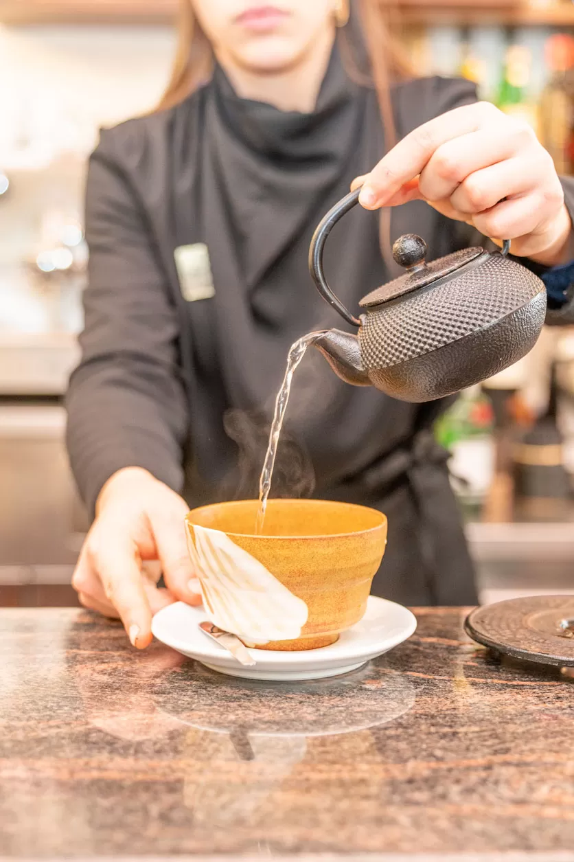 Ulteriore versamento d’acqua nella tazza – equilibrio tra gesto e immagine