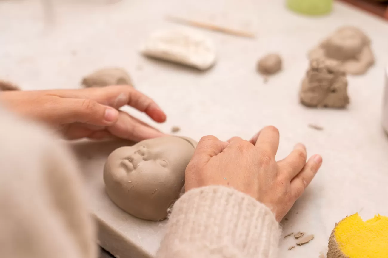 Dettaglio della scultura grezza in terracotta tra le mani di Chiara Ripoli – momento di modellazione