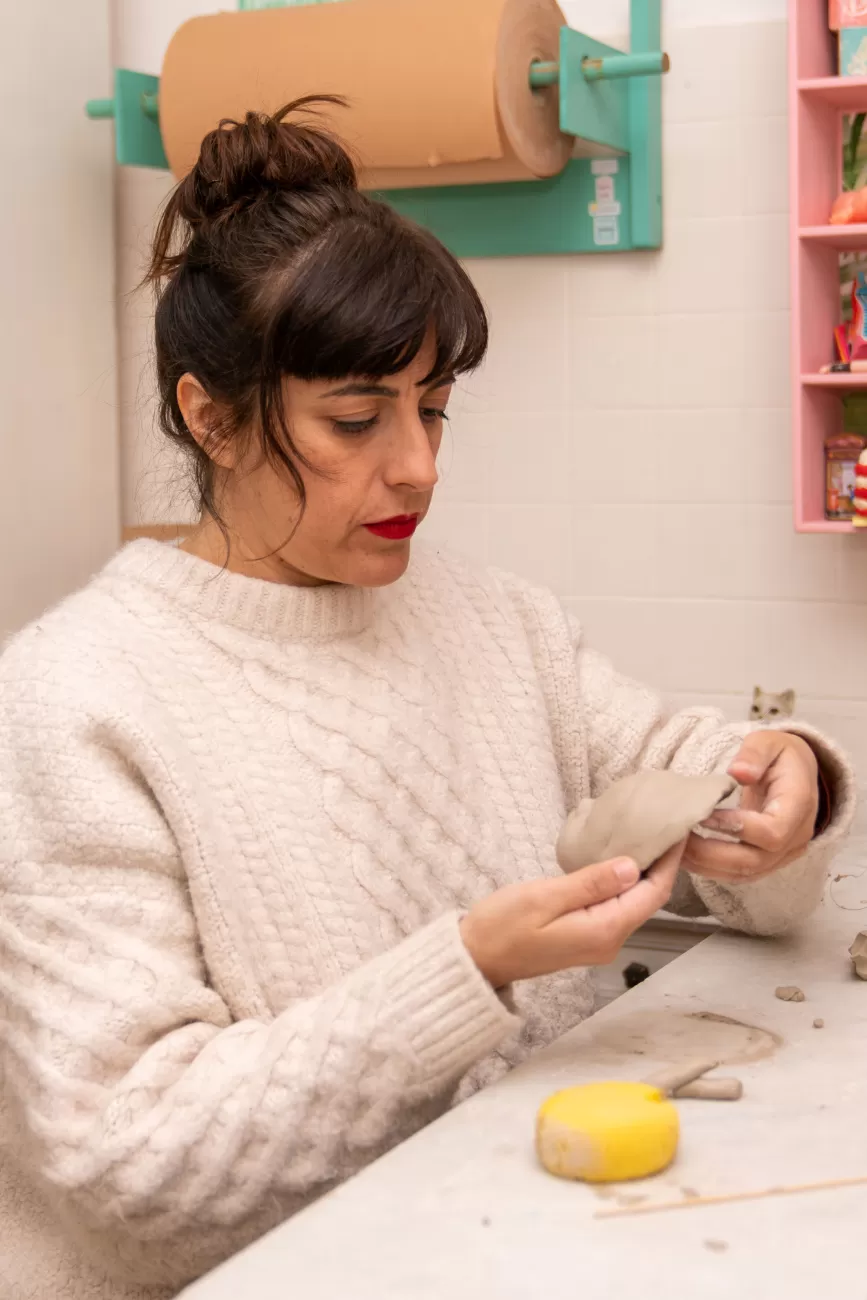 Chiara Ripoli osserva il volto modellato della sua scultura – verifica del lavoro