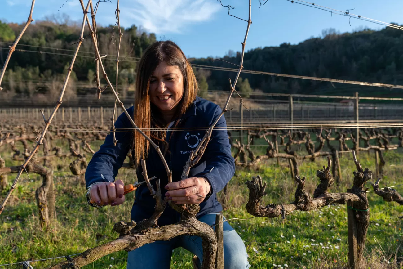 Letizia Martelli pota la vite nei filari della Tenuta La Macchia – cura del vigneto