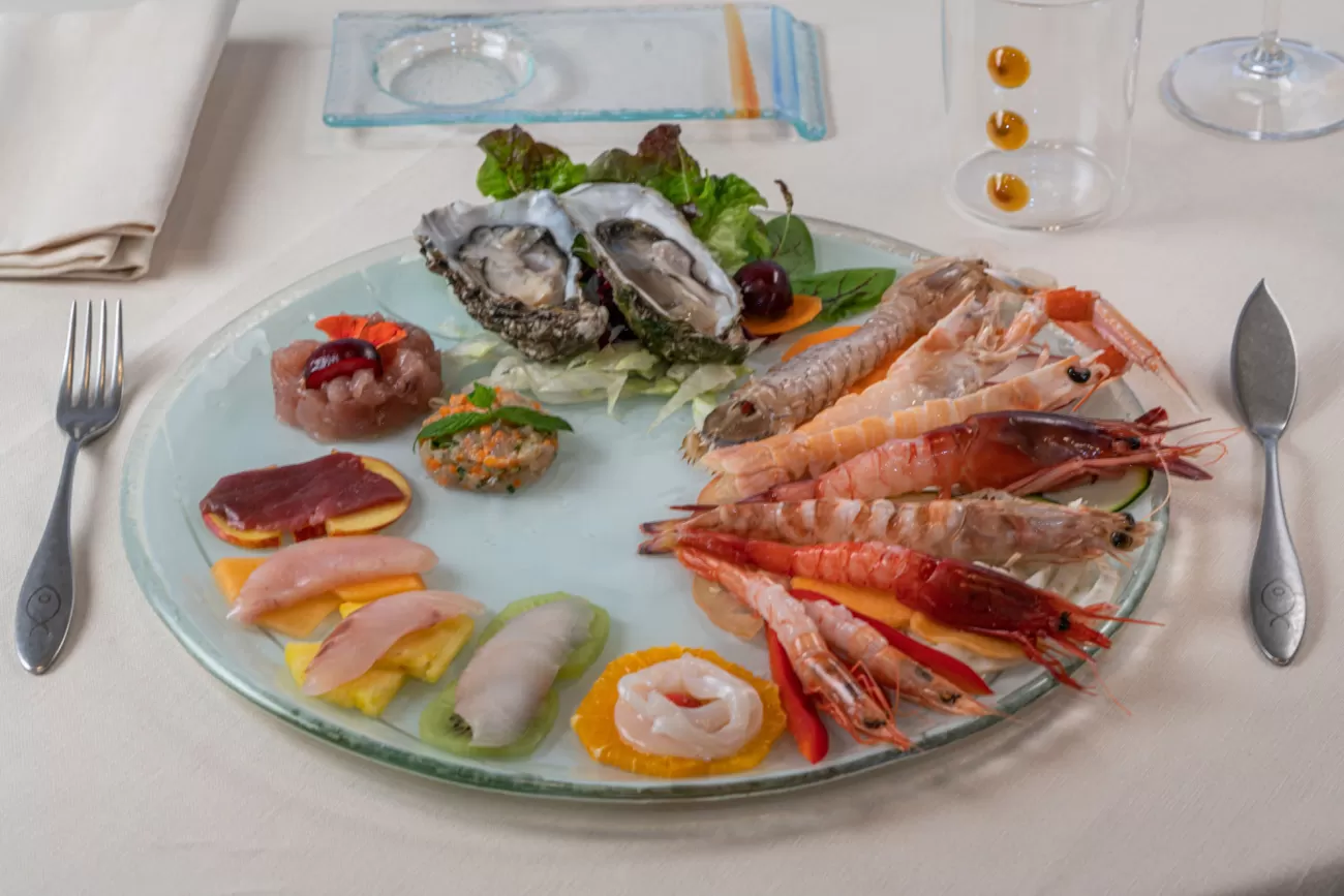 Crudité di mare con scampi, cicale, gamberi rossi crudi, ostriche, tartare e carpacci di pesce su letto di frutta fresca – fotografia food professionale