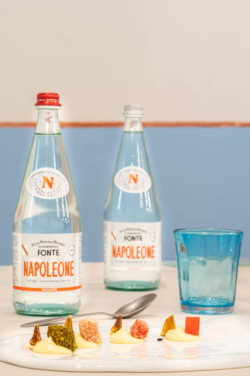 Cocomero in quattro cotture con crema chantilly – sullo sfondo acqua Fonte Napoleon – food photography per dessert innovativi