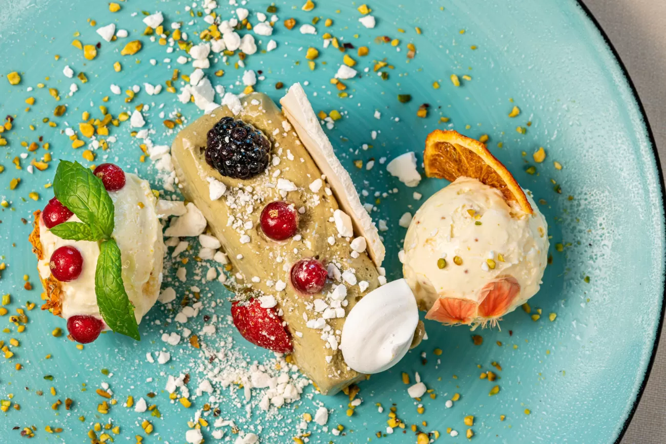 Dettaglio fotografico di semifreddo al pistacchio con meringa e frutti di bosco – food photography per ristoranti