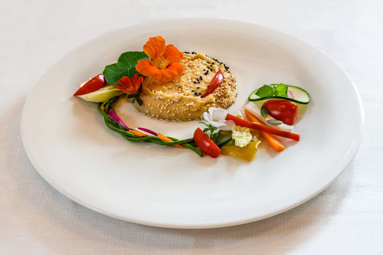 Primo piatto vegano con hummus di ceci e verdure – fotografia food per ristoranti