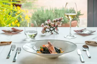 Tagliolini al nero di seppia con scampi e asparagi, piatto simbolo del Ristorante Il Doretto – Cecina, Toscana